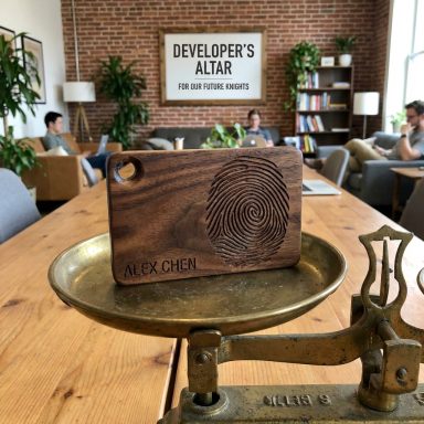 Holztablett mit Fingerabdruck-Gravur in einem modernen Arbeitsraum.